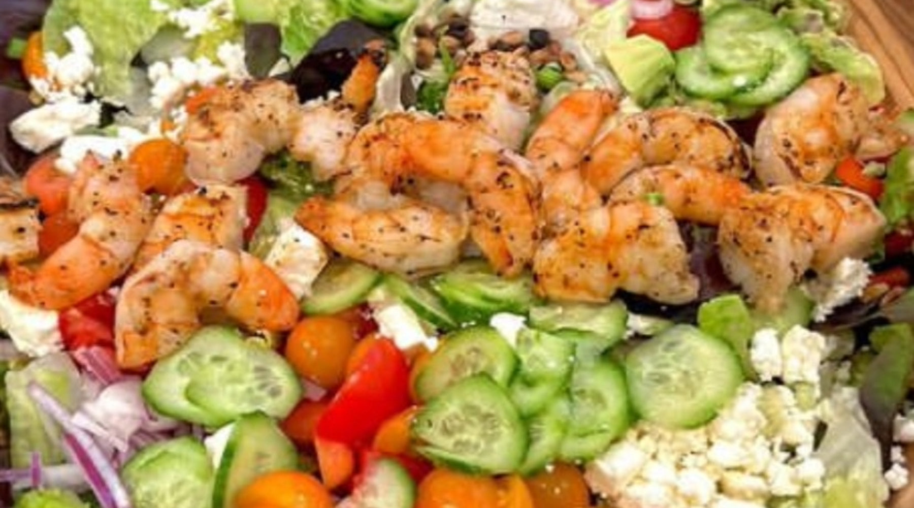 Grilled shrimp topping a salad