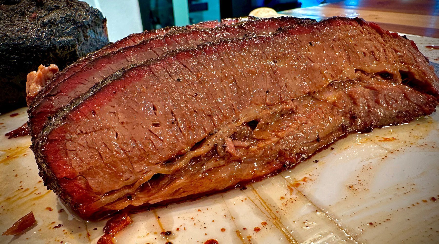 Thick slice of brisket that is just dripping in liquid gold and ready to eat.