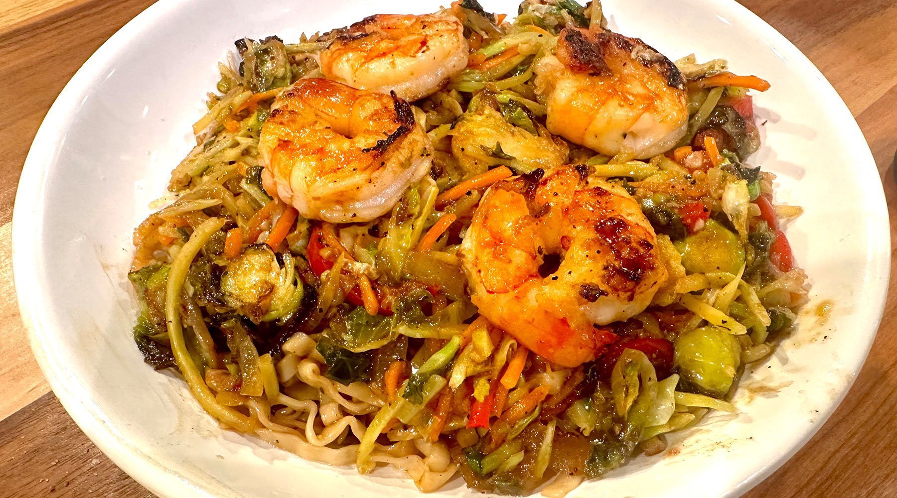 Bowl of noodles with vegetables and grilled shrimp