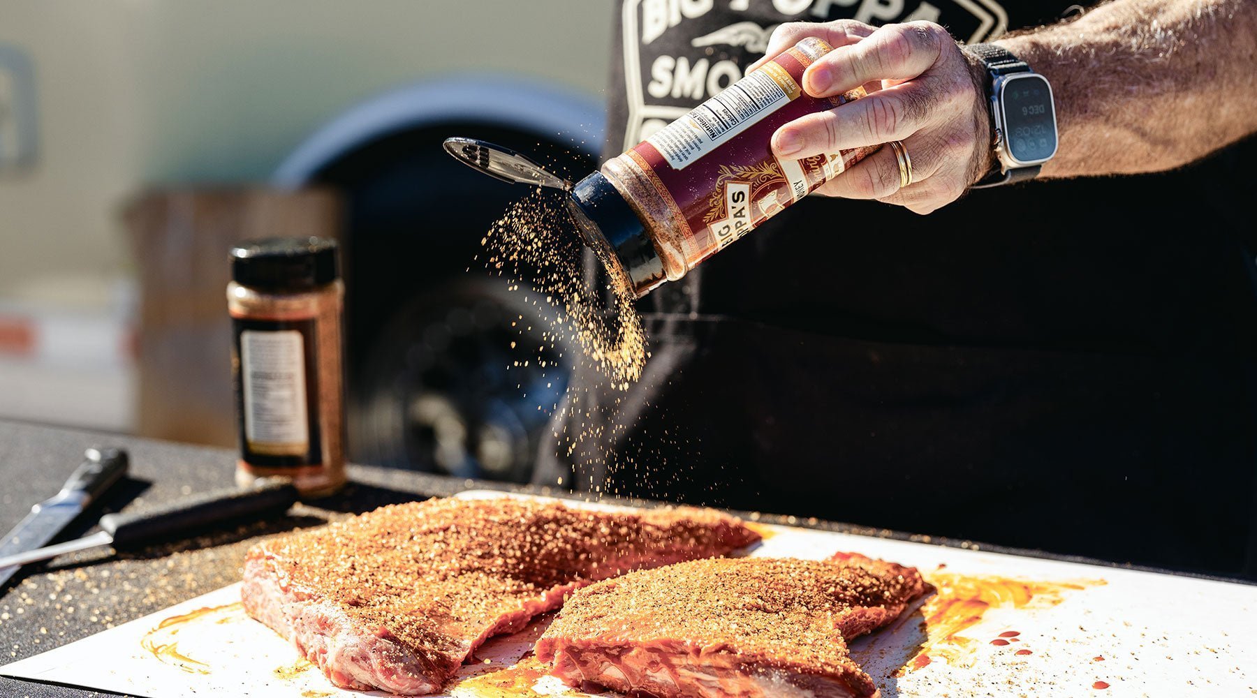 Big Poppa seasoning the tri-tip before going on the grill