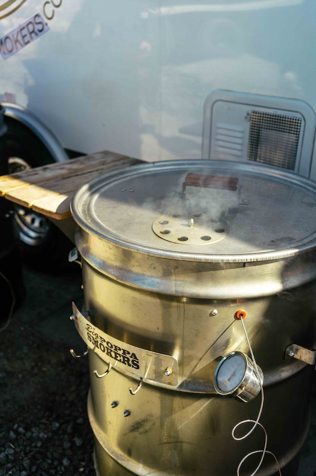 Close-up of stainless steel drum's textured surface with visible welds and smoked patina, highlighting craftsmanship and