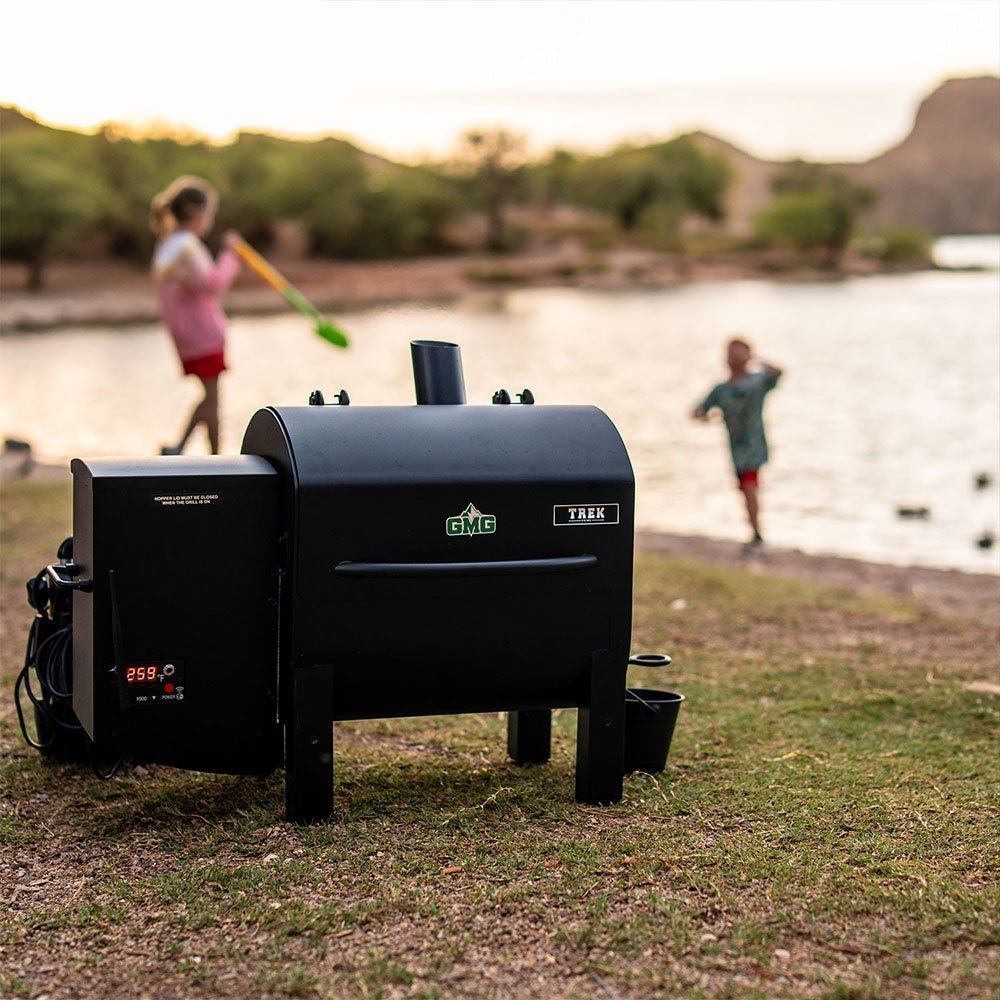 Close-up of the GMG TREK PRIME 2.0 grill's stainless steel lid handle and textured surface detail from a top-front angle.