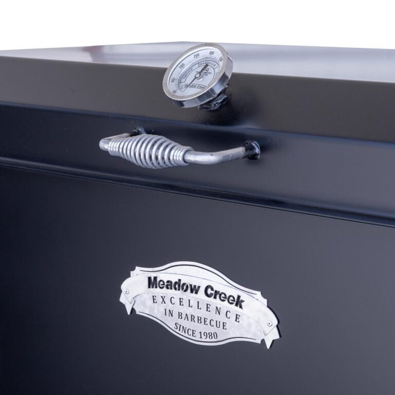 Close-up of the Meadow Creek BBQ42 Chicken Cooker’s cast iron cooking grate with textured surface and embedded branding logo