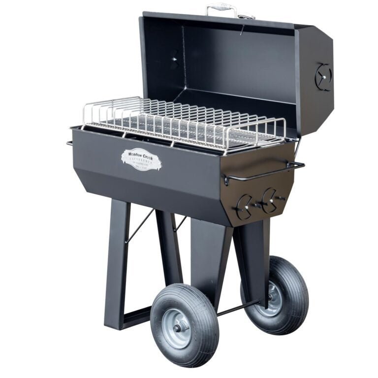 Close-up of the 36-inch stainless steel cooking grate with textured surface and engraved Meadow Creek logo on the PR36 pig