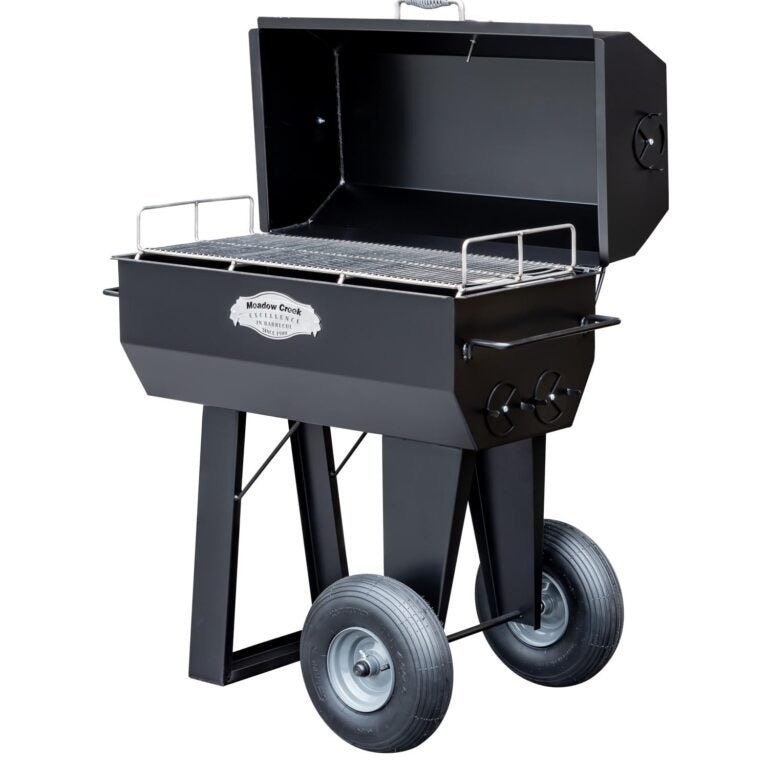 Close-up of the cylindrical stainless steel pig roaster with adjustable rotating spit and textured cooking chamber interior.