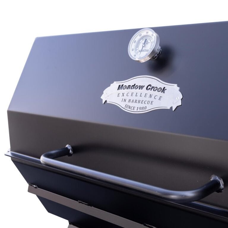 Close-up of the sturdy stainless steel lid latch and textured surface of the Meadow Creek PR42 Pig Roaster from an angled