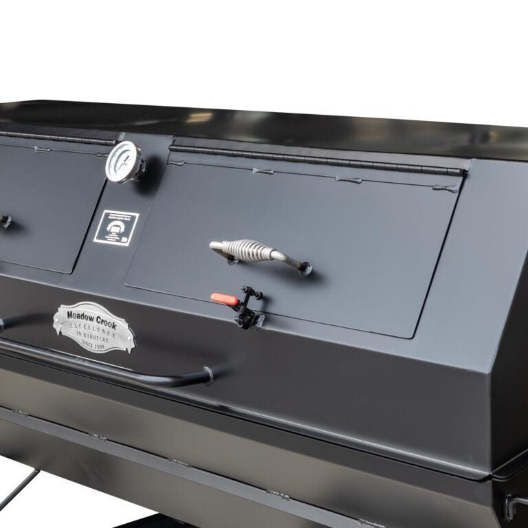 Close-up of the heavy-duty stainless steel cooking grate with integrated drip tray on the Meadow Creek PR42 pig roaster