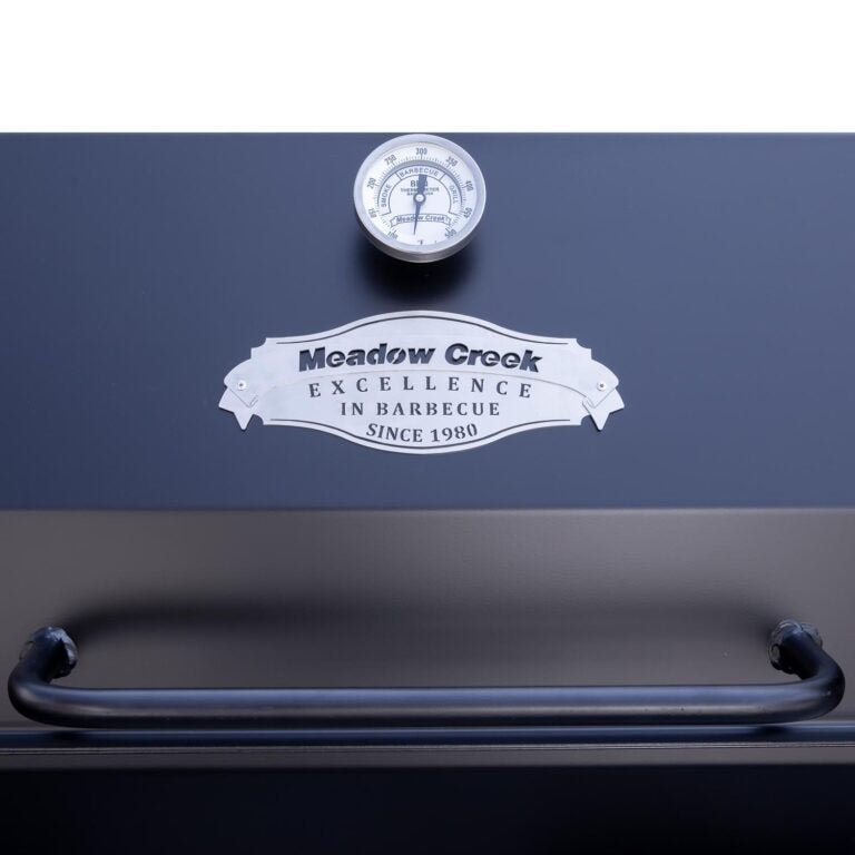 Close-up of the 12-gauge stainless steel roasting basket with textured grip handle on Meadow Creek PR72 Pig Roaster for