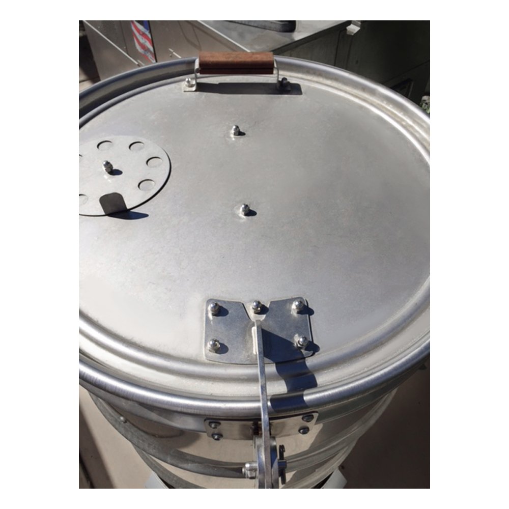 Close-up of the welded steel hinge mounted on textured, matte black lid edge with visible mounting screws for BPS Drum
