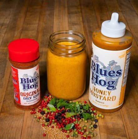 Close-up of the squeezable bottle tip highlighting the smooth, honey mustard sauce texture and vibrant label design