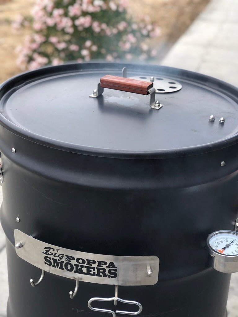 Close-up of textured black carbon steel drum lid with built-in thermometer and latch detail on BPS Carbon Drum Smoker Kit