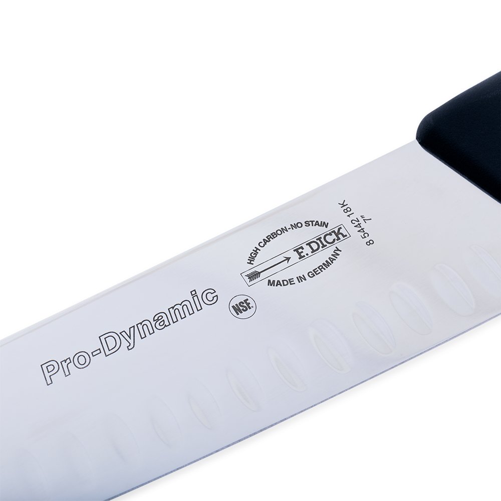 Close-up of the 7" blade edge highlighting the Kullenschiff hollow ground indentations and textured stainless steel surface.