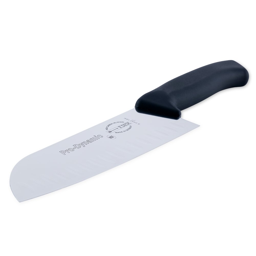 Close-up of the 7-inch blade edge with visible kullenschiff indentations and textured stainless steel surface from a