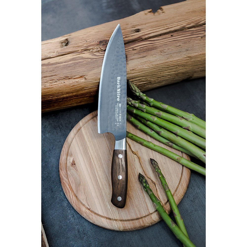 Close-up of the F. Dick DarkNitro chef's knife handle showcasing textured black grip and engraved branding at a slight angle