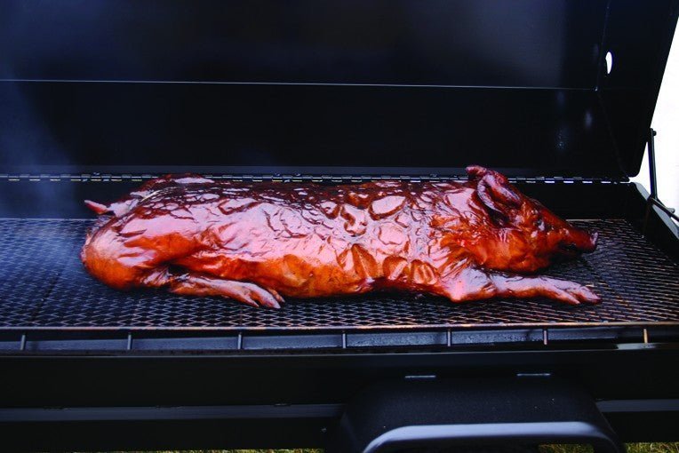 Close-up of the heavy-duty steel cooking grate with textured surface and adjustable charcoal tray in the foreground