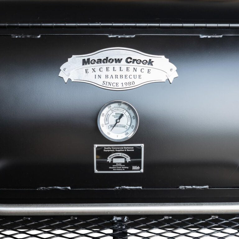 Close-up of the black steel lid latch and handle on the Meadow Creek TS120P Offset BBQ Smoker showing textured surface and