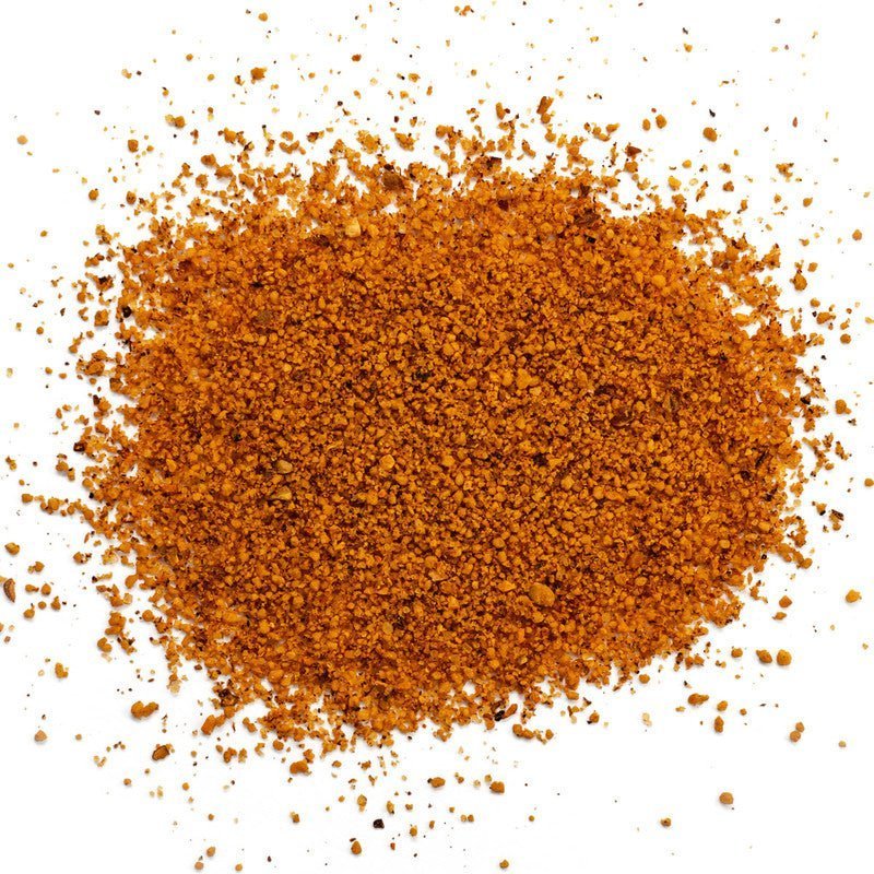 Cracked surface of Simply Marvelous BBQ Genie's Trinity Rub 12oz with visible ingredient specks and textured finish detail